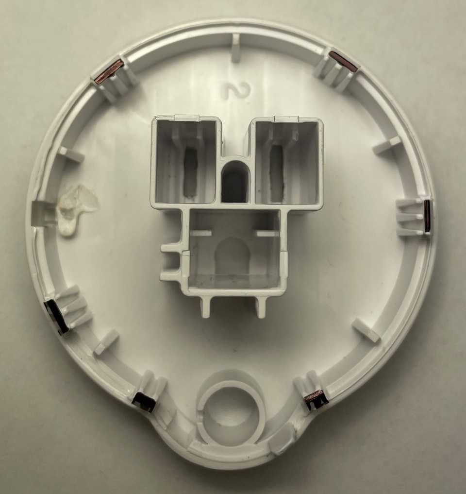 A top-down back view of the inside of the front shell of an Etekcity Voltson ESW01-USA-R6P Smart Outlet. There are black marks on each of the six clips of the plastic shell. The clips are positioned clockwise at 35°, 90°, 155°, 205°, 240°, and 320°.